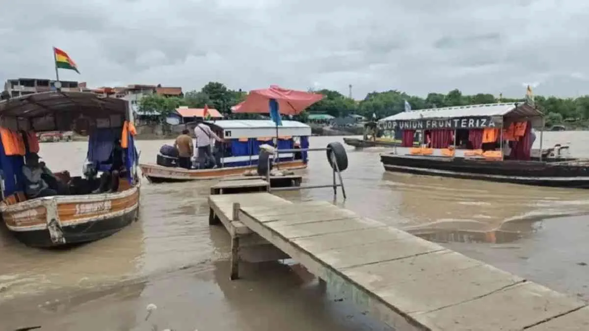 Chalanas amarradas en el puerto de Aguas Blancas sobre el río Bermejo, con el agua marrón y crecida