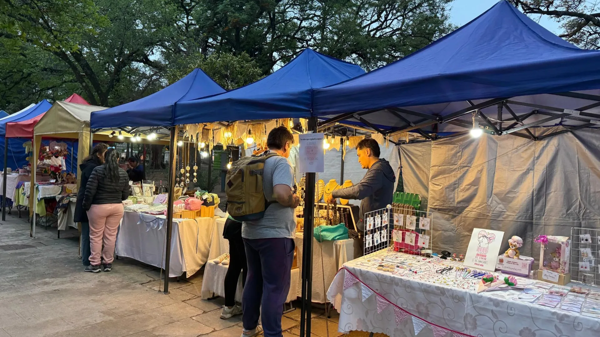 Puestos de la feria artesanal bajo gazebos azules en plaza Güemes, en la ciudad de Salta