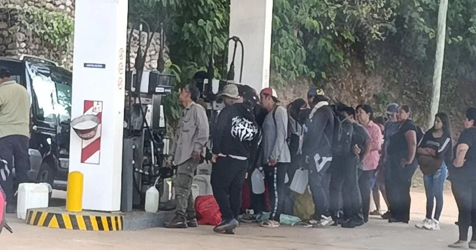 Fila de personas con bidones frente a los surtidores de una estación de servicio en la frontera salteña
