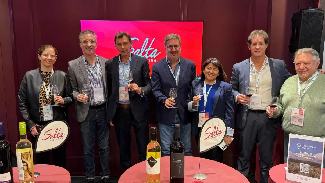 Representantes del turismo y la hotelería salteña brindan con copas de vino en el stand de Salta en Hotelga, con botellas de bodegas salteñas sobre las mesas
