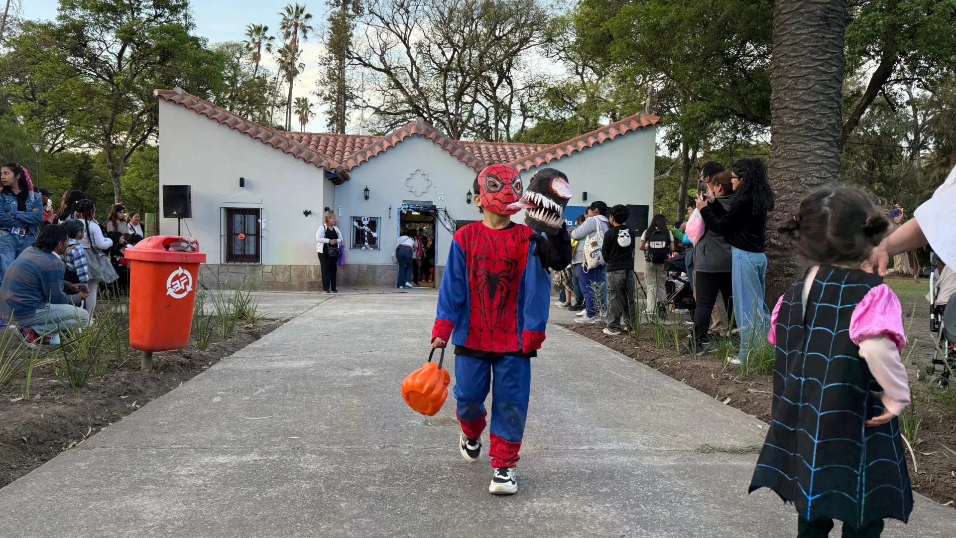 Un nene disfrazado de Spider-Man camina con una calabaza de caramelos frente a la Casita del Parque San Martín, en Salta, durante el Halloween municipal