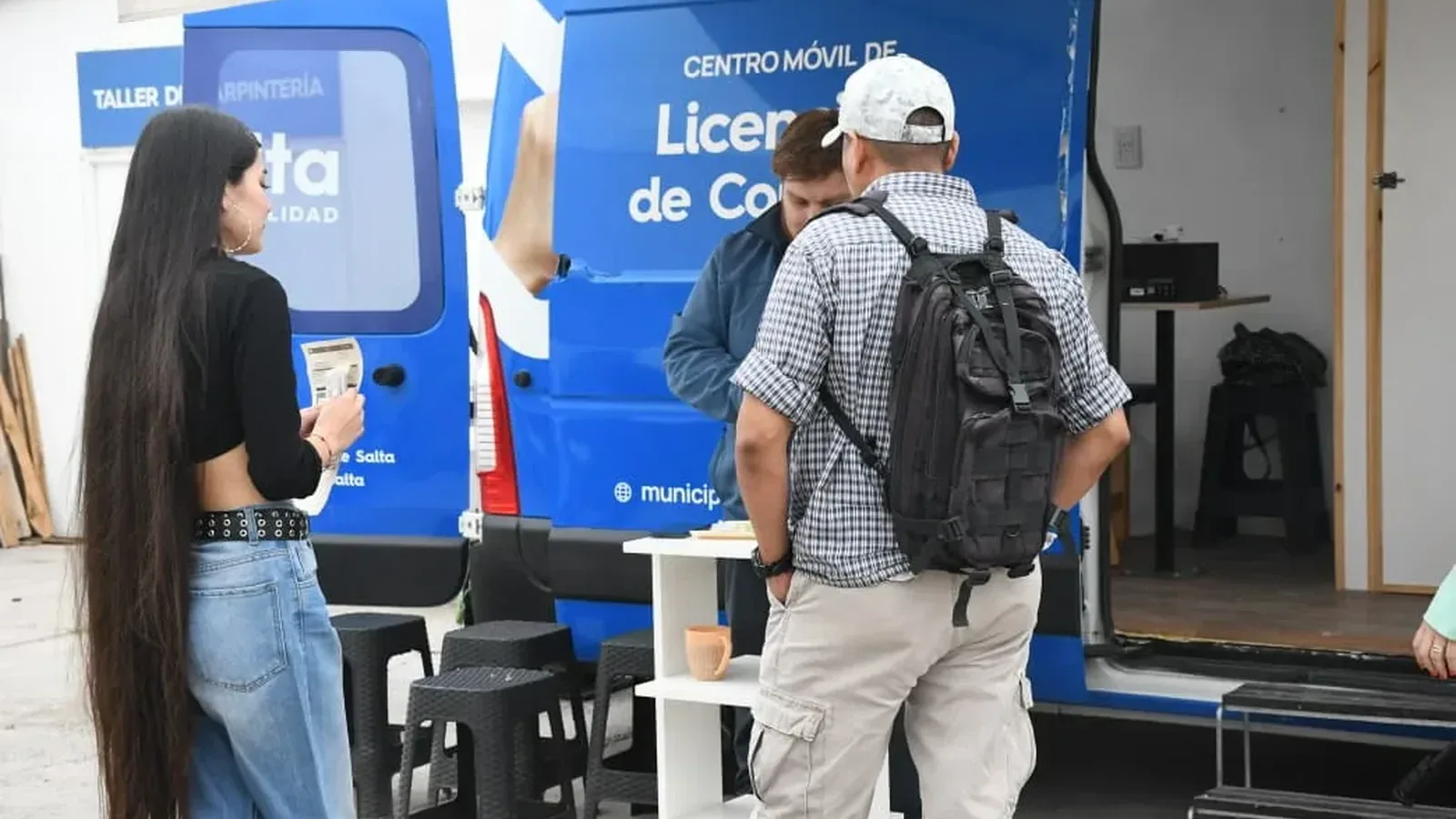 Un vecino es atendido junto al camión azul del Centro Móvil de Licencias de Conducir