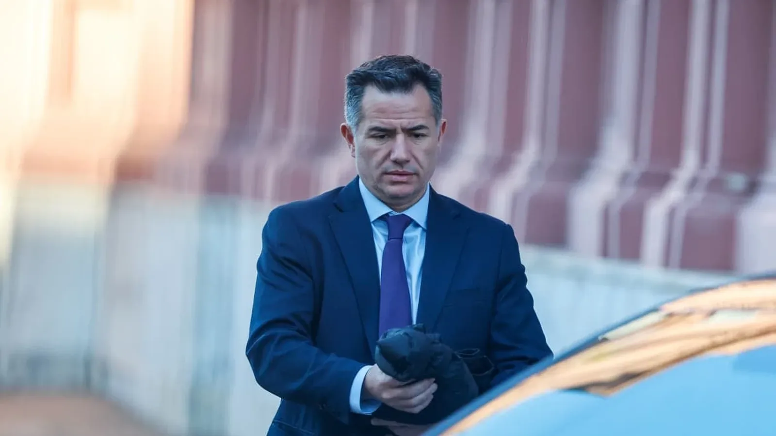 Un legislador camina hacia el ingreso del Congreso antes de la sesión