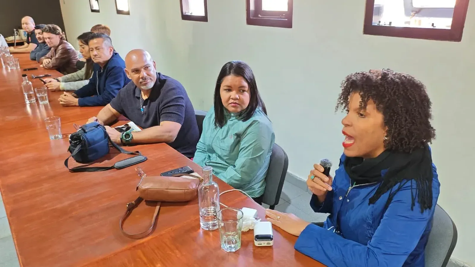 Una participante habla por micrófono durante una reunión del foro en torno a una mesa de trabajo