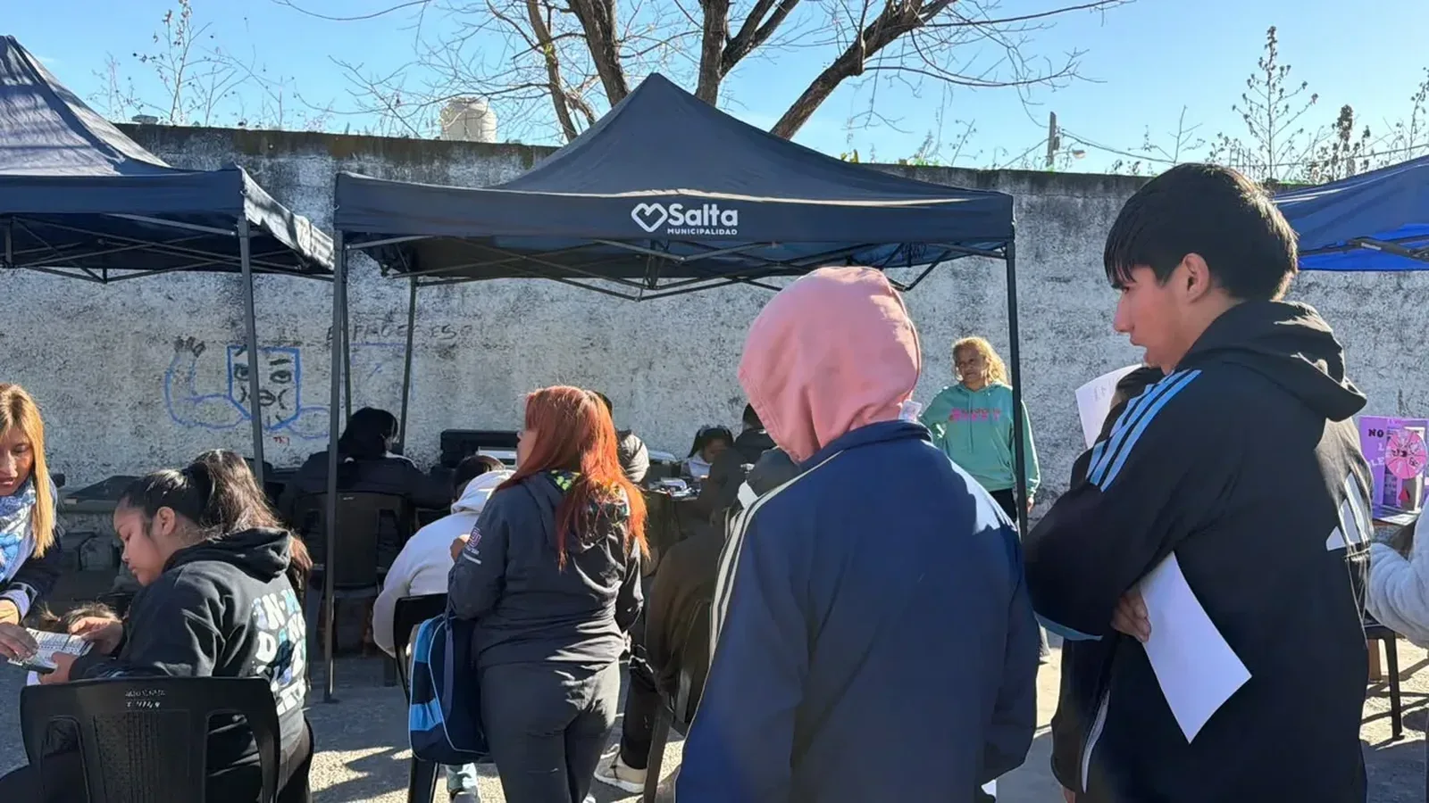 Vecinos se acercan a un puesto de atención para acceder a servicios de salud, trámites y asesoramiento.