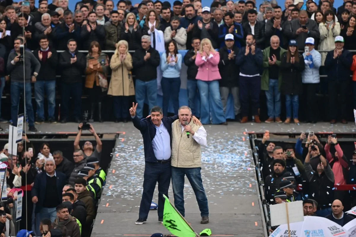 Osvaldo Jaldo, con el micrófono, abrazado con Miguel Acevedo en el escenario del Hipódromo de Tucumán ante la militancia