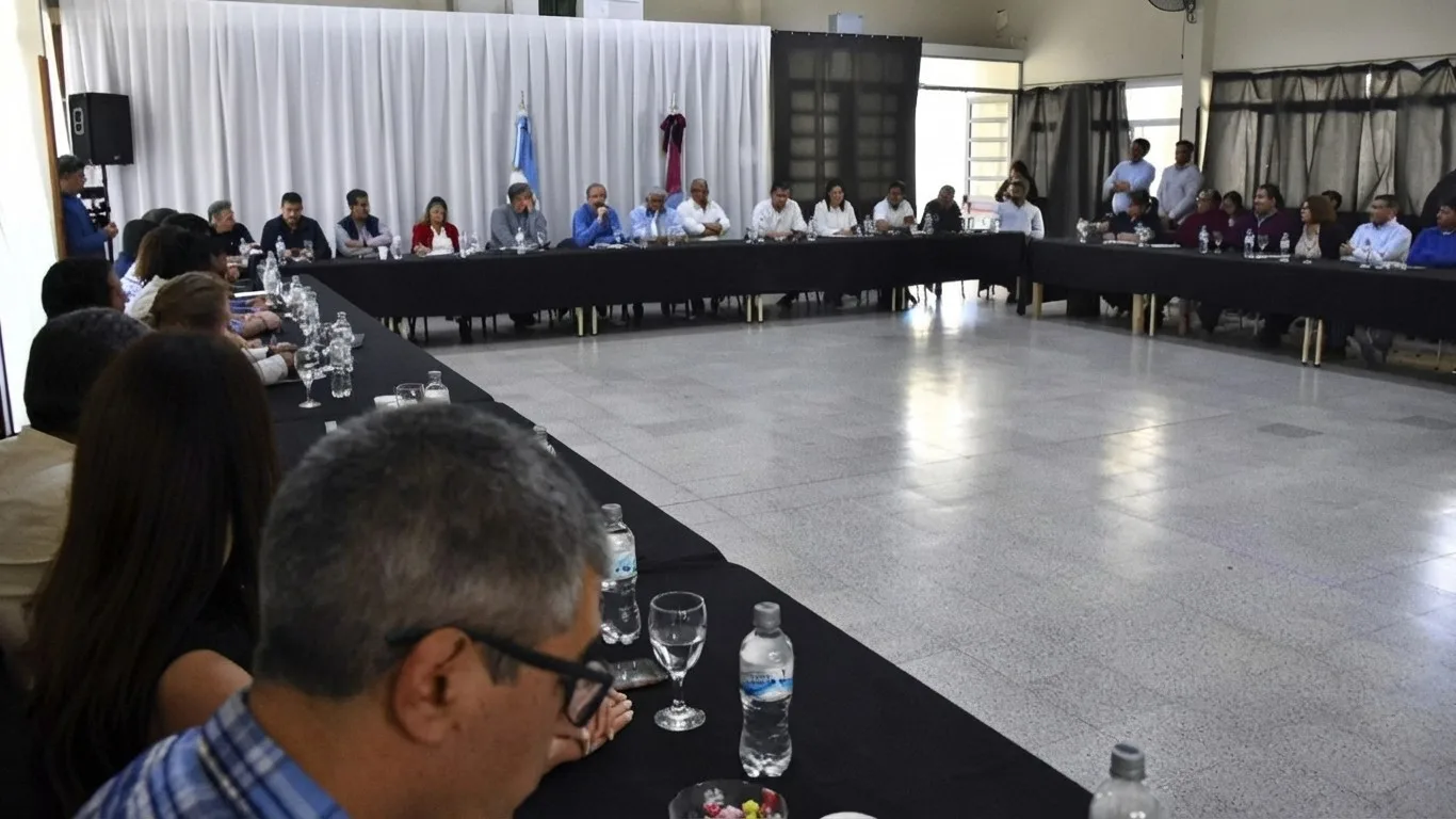 Intendentes, legisladores y funcionarios sentados alrededor de una mesa en U en un salón de Molinos